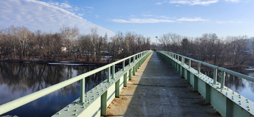 Pedestrian bridge leading forward over water symbolizing a clear path toward building an online business.